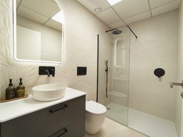 Moderne badkamer met wastafel, douche en toilet.