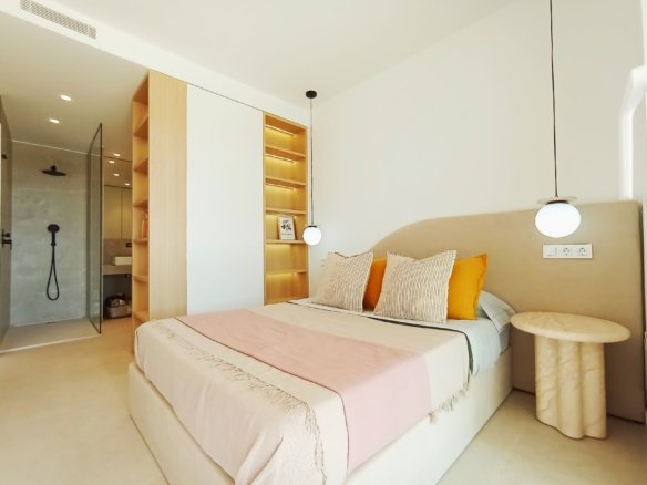 Moderne slaapkamer met een tweepersoonsbed, boekenplank, nachttafeltje, en open douche.