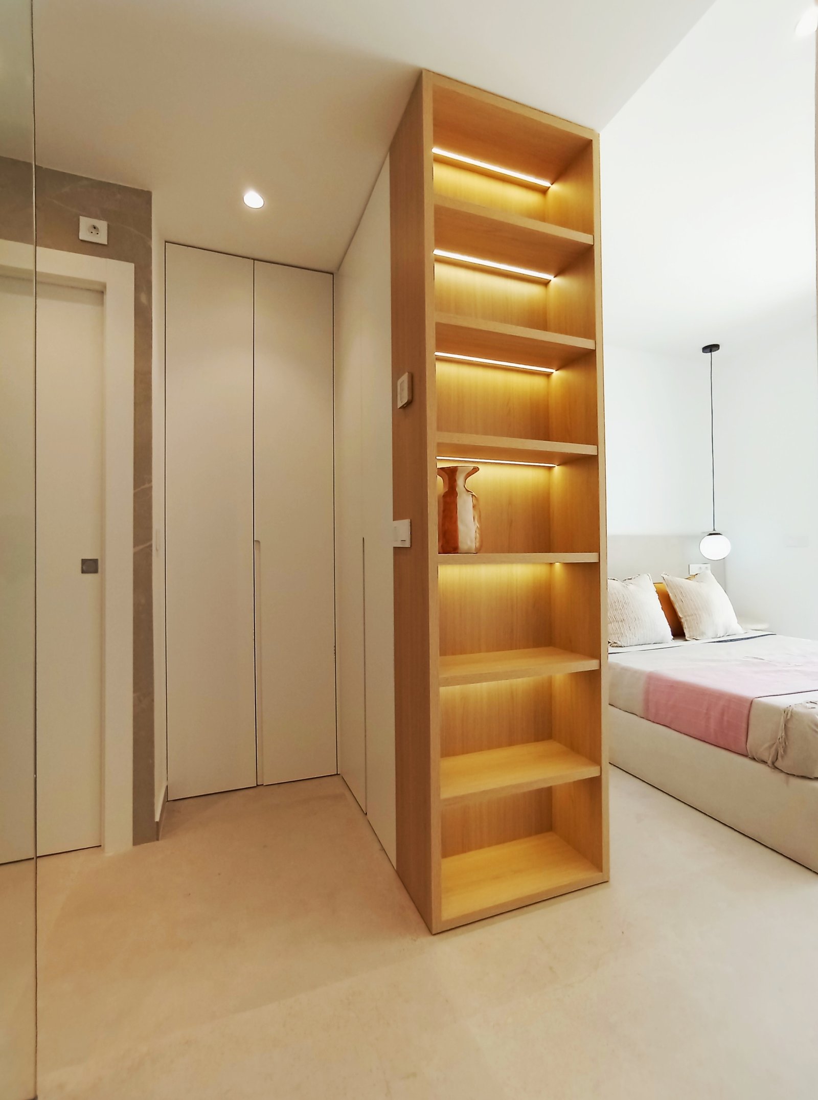 Moderne slaapkamer met open kast en lichte boekenkast.